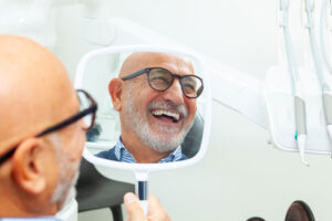 patient smiling in a dental chair after a treatment, smiling, white room, dental office