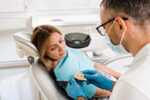 Patient consulting with a dentist about dentures in a modern dental office.